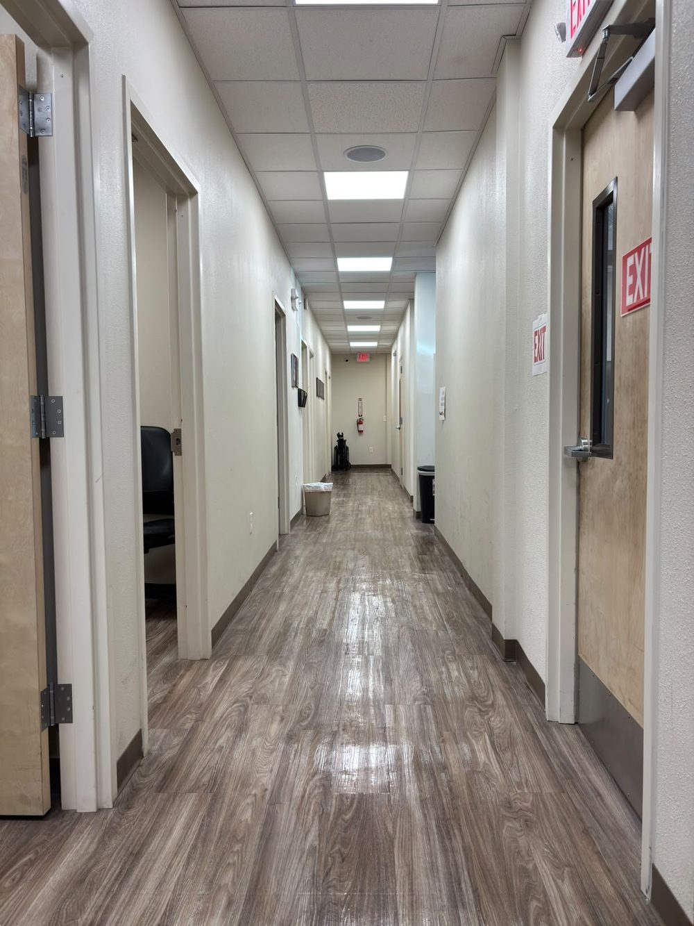 Office corridor with wood-look vinyl plank flooring cleaned and buffed to an even sheen