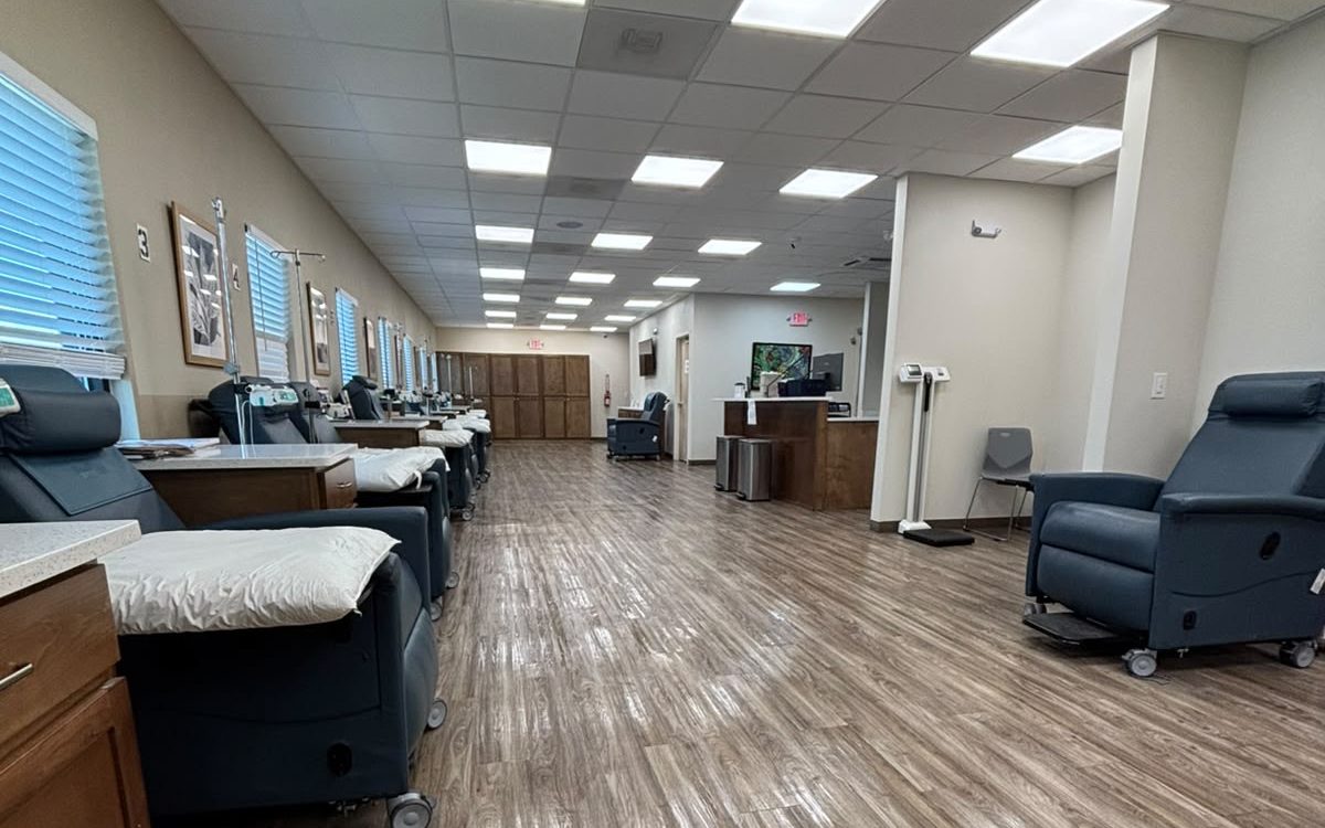 Open treatment floor of a medical clinic with recliner chairs and freshly cleaned wood-look flooring